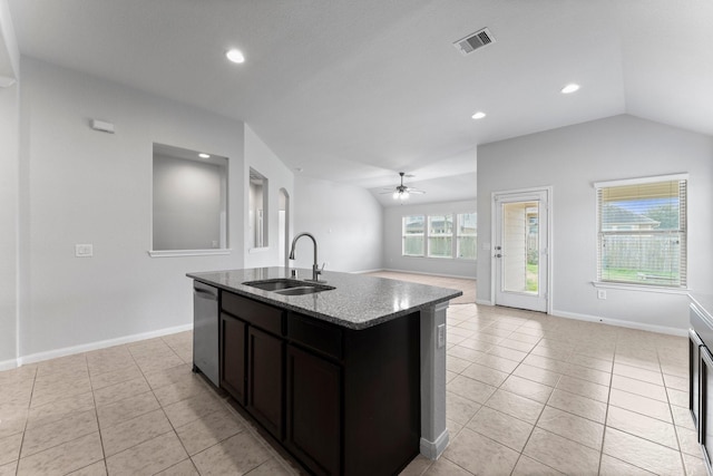 kitchen featuring sink, dishwasher, light stone counters, an island with sink, and vaulted ceiling