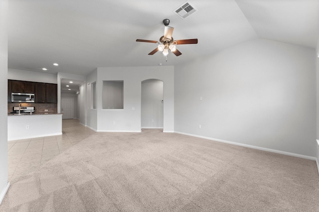 unfurnished living room with light carpet, vaulted ceiling, and ceiling fan