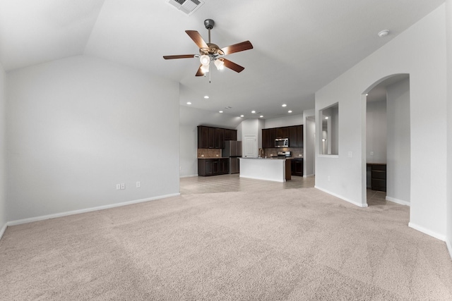 unfurnished living room with lofted ceiling, light colored carpet, and ceiling fan