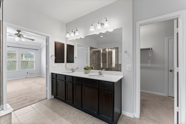 bathroom with ceiling fan, vanity, an enclosed shower, and tile patterned flooring