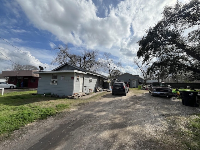 view of side of property featuring cooling unit and a storage unit