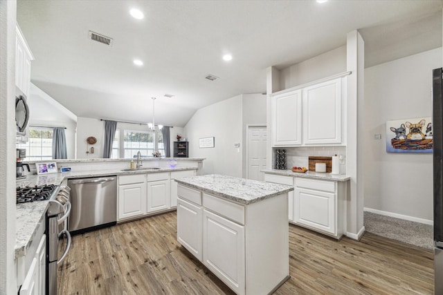 kitchen featuring pendant lighting, white cabinetry, sink, a center island, and stainless steel appliances