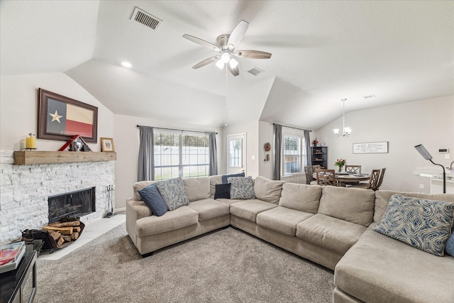 living room featuring a stone fireplace, vaulted ceiling, ceiling fan with notable chandelier, and plenty of natural light