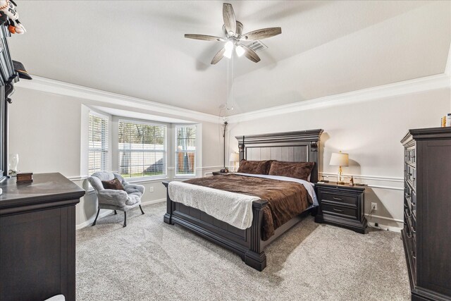 carpeted bedroom with vaulted ceiling, ceiling fan, and crown molding