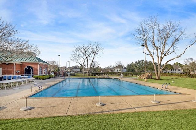 view of pool with a lawn and a patio area