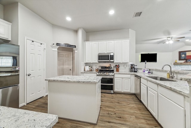 kitchen featuring sink, stainless steel appliances, kitchen peninsula, and white cabinets