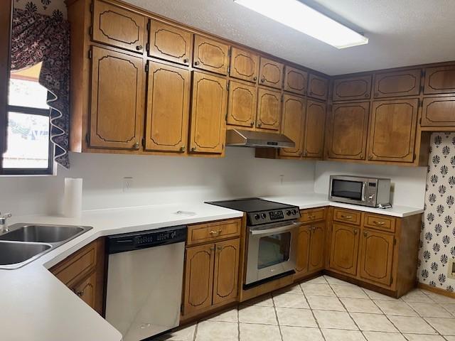 kitchen with sink, light tile patterned flooring, and appliances with stainless steel finishes