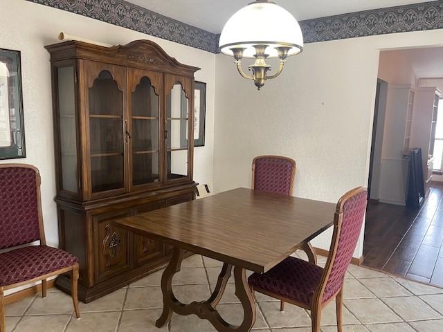 dining area featuring light tile patterned floors and a chandelier