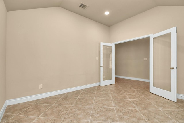 interior space with french doors, vaulted ceiling, and light tile patterned floors