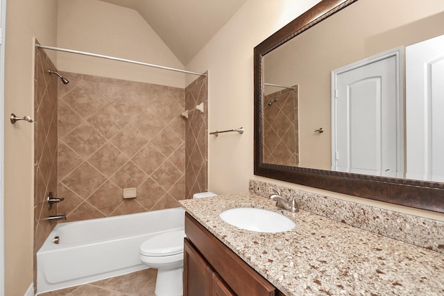 full bathroom featuring vaulted ceiling, tiled shower / bath combo, vanity, toilet, and tile patterned floors