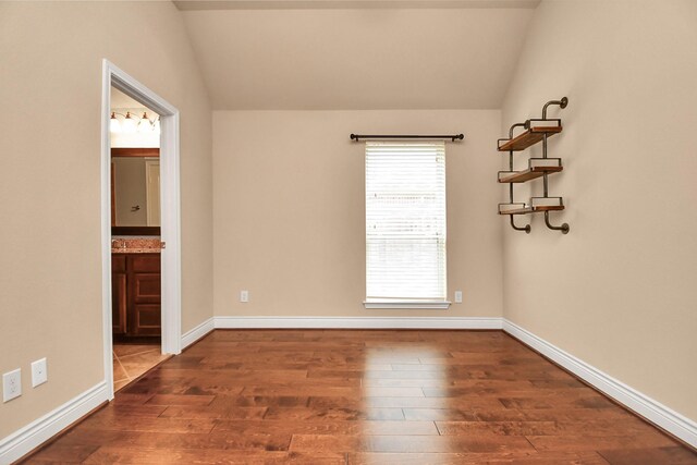 unfurnished room with lofted ceiling and dark hardwood / wood-style floors