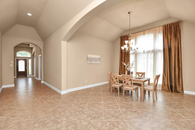 tiled dining room with lofted ceiling and a chandelier