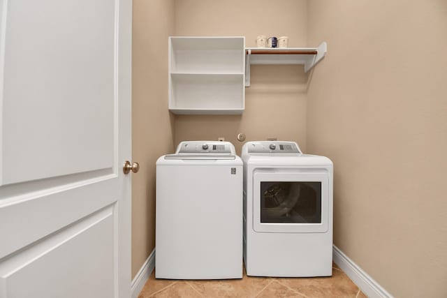 laundry room featuring washer and clothes dryer and light tile patterned flooring