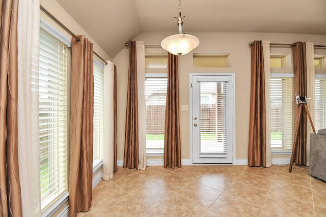 entryway with light tile patterned flooring and lofted ceiling