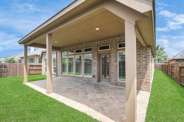 rear view of house with a yard and a patio