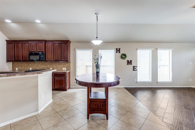 kitchen featuring tasteful backsplash, hanging light fixtures, vaulted ceiling, and plenty of natural light