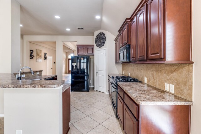 kitchen with tasteful backsplash, light tile patterned floors, sink, and black appliances