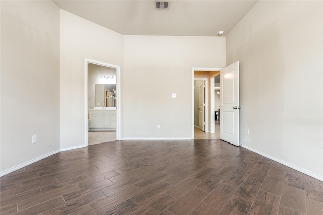 unfurnished room featuring a high ceiling and dark wood-type flooring