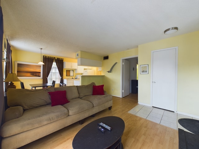 living room with a textured ceiling and light wood-type flooring