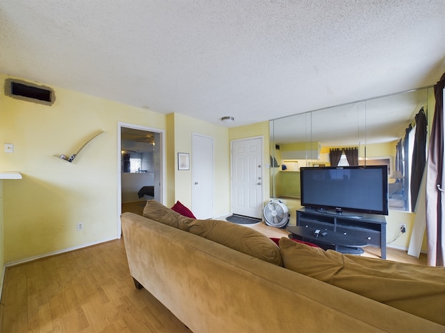 living room with a textured ceiling and light wood-type flooring