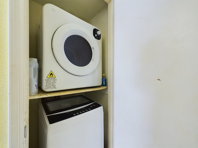 washroom featuring stacked washing maching and dryer