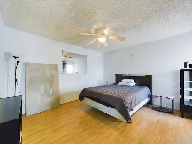 bedroom featuring a textured ceiling, ceiling fan, and light hardwood / wood-style flooring