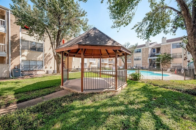 view of community featuring a pool, a gazebo, and a yard