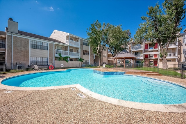 view of swimming pool with a gazebo and cooling unit