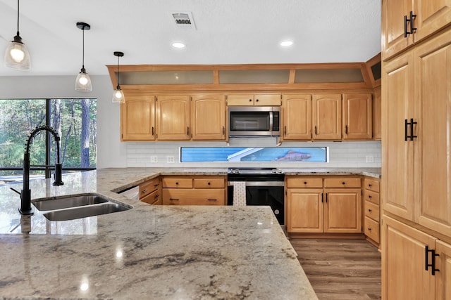 kitchen with hanging light fixtures, range with electric cooktop, light stone countertops, and sink