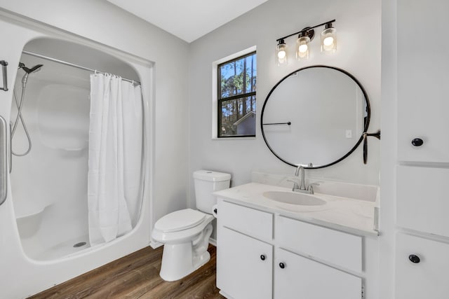 bathroom featuring hardwood / wood-style flooring, vanity, toilet, and walk in shower