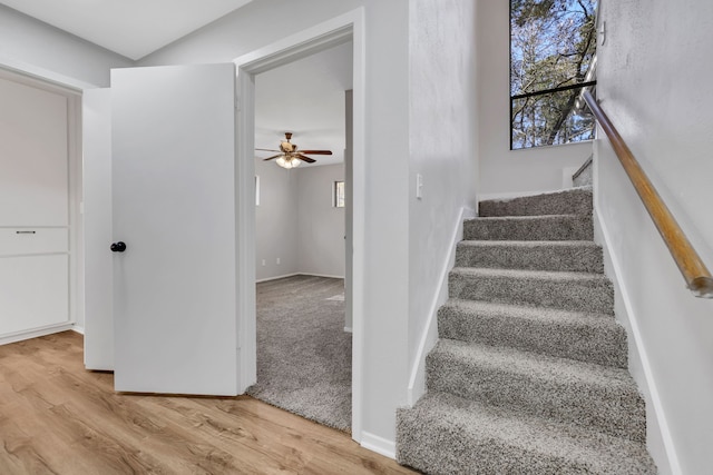 stairway with hardwood / wood-style floors and ceiling fan