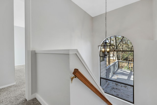 stairs featuring carpet and a notable chandelier