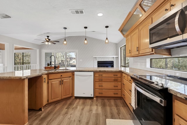 kitchen featuring lofted ceiling, sink, black electric range, dishwasher, and hardwood / wood-style flooring