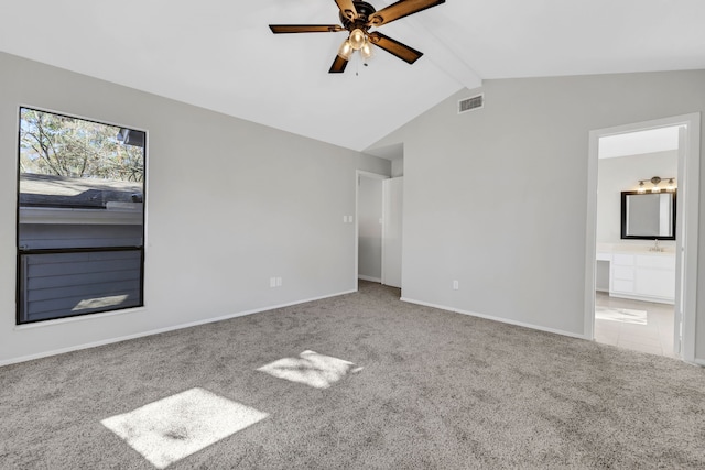 unfurnished room featuring lofted ceiling with beams, ceiling fan, and carpet