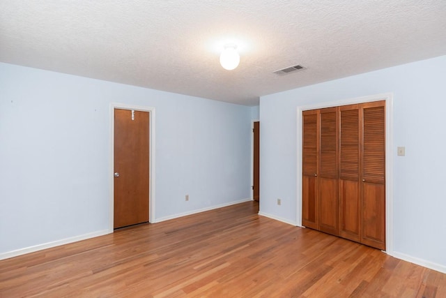 unfurnished bedroom featuring a textured ceiling and light wood-type flooring