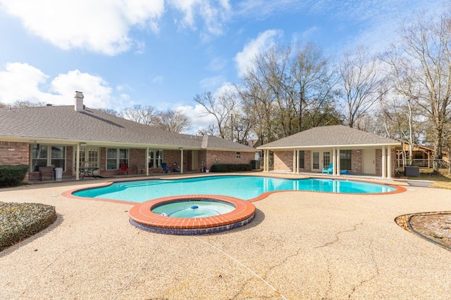 view of pool featuring an in ground hot tub, a patio area, and cooling unit