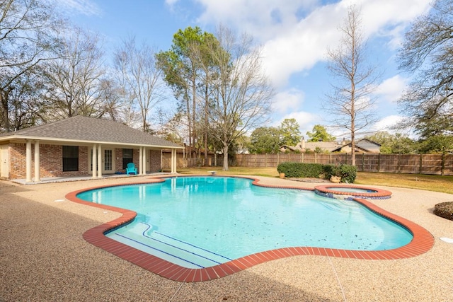 view of swimming pool featuring an in ground hot tub, a patio, and an outbuilding