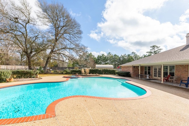 view of swimming pool with an in ground hot tub, a patio, and french doors