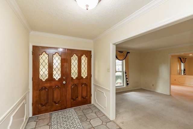 entryway with light carpet, ornamental molding, and a textured ceiling