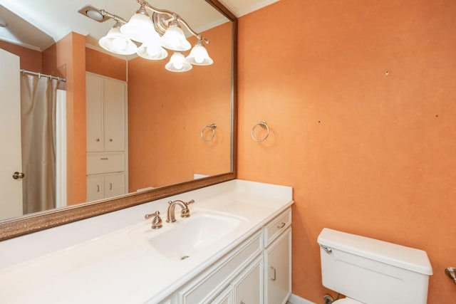 bathroom with vanity, toilet, and a chandelier