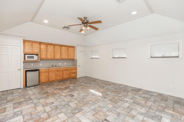 kitchen featuring vaulted ceiling, tasteful backsplash, sink, dishwashing machine, and ceiling fan