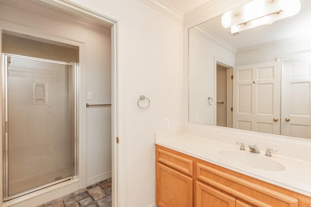 bathroom with ornamental molding, vanity, and a shower with shower door