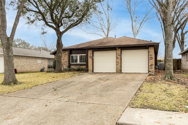 single story home featuring cooling unit, a garage, and a front yard