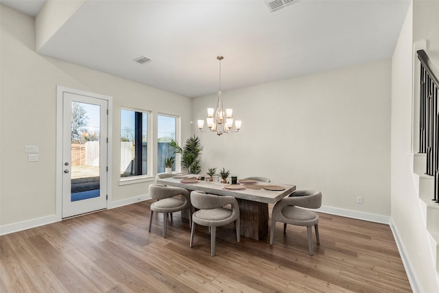 dining room with hardwood / wood-style floors and a notable chandelier