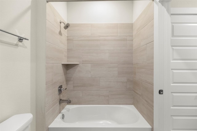 bathroom with tiled shower / bath and toilet