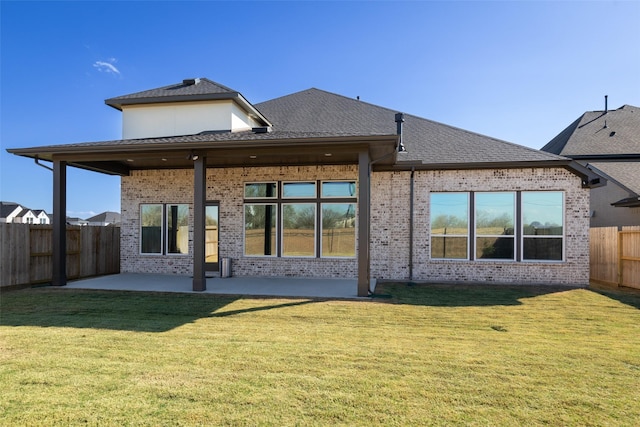 rear view of house with a patio and a lawn