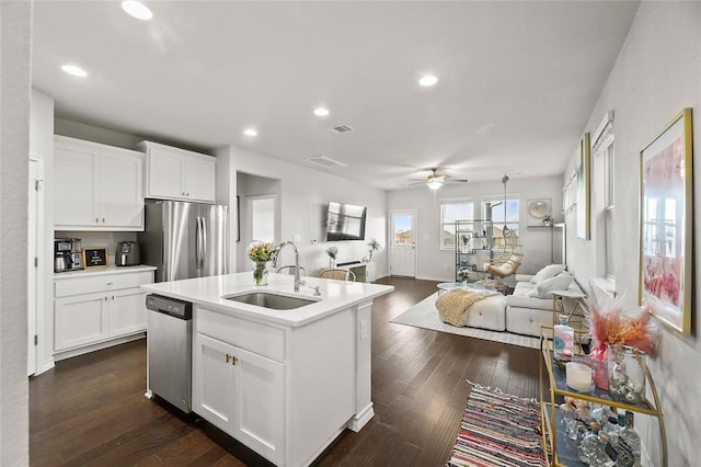 kitchen featuring sink, appliances with stainless steel finishes, dark hardwood / wood-style floors, an island with sink, and white cabinets