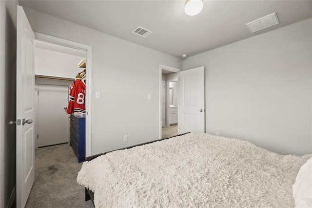 carpeted bedroom with a walk in closet and a closet