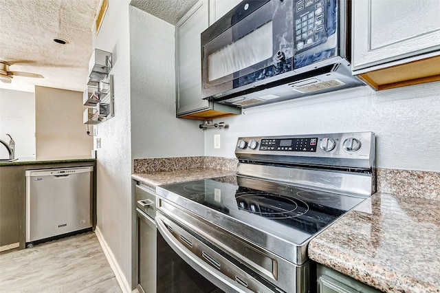 kitchen featuring appliances with stainless steel finishes, a textured ceiling, and light hardwood / wood-style flooring