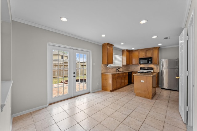 kitchen with french doors, crown molding, a kitchen island, light stone countertops, and black appliances